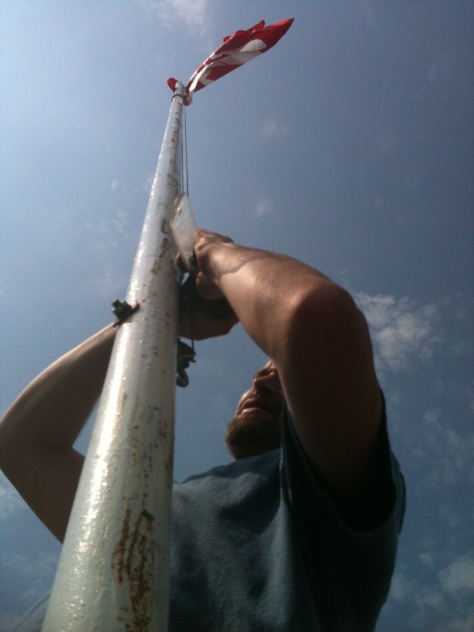 Flag Huronia Museum maintenance manager Calvin Watts puts up a fresh new flag in anticipation of Canada Day.